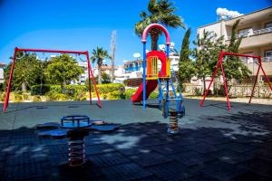 a playground with a slide and a swing at 6 bdr villa with TENNIS COURT in Paphos City