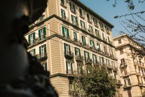 Un edificio alto con puertas y balcones verdes. en The Grey, en Nápoles