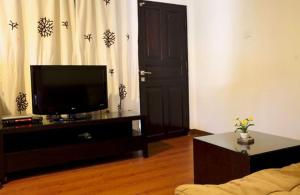 ein Wohnzimmer mit einem Flachbild-TV und einem Sofa in der Unterkunft Niramaya Villa in Seminyak