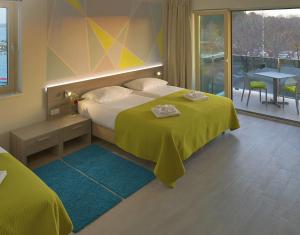 a hotel room with a bed, table, and window at Hotel Modo in Pula