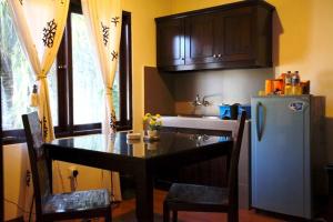 een keuken met een tafel en een koelkast bij Niramaya Villa in Seminyak