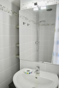 ein weißes Bad mit einem Waschbecken und einer Dusche in der Unterkunft Coup de coeur assuré pour cette charmante maison à 400 m de la plage in Saint-Gilles-Croix-de-Vie