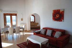 モライラにあるBook It Villa Attias Morairaのリビングルーム(赤いソファ、テーブル付)