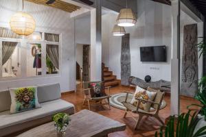 a living room with a couch and chairs and a tv at Smiling Cactus Villas - Seminyak in Seminyak +72 photos