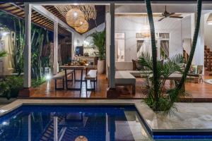 a house with a swimming pool and a living room at Smiling Cactus Villas - Seminyak in Seminyak