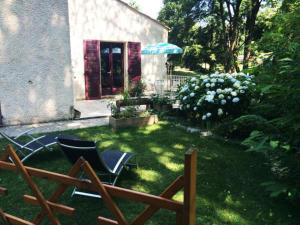 a yard with two chairs and an umbrella at Studio duplex 2 Lac des Montagnès in Mazamet