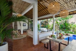 a living room with a table and a pool at Smiling Cactus Villas - Seminyak in Seminyak