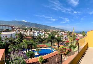 a view of a city from a balcony with a swimming pool at Apartamentos Tigaiga Suites in Puerto de la Cruz