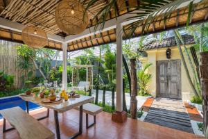 an outdoor dining area with a table and chairs at Smiling Cactus Villas - Seminyak in Seminyak