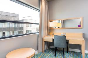 a desk and chair in a room with a large window at Quality Hotel Fredrikstad in Fredrikstad