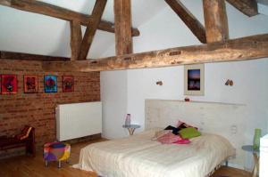 1 dormitorio con cama blanca y pared de ladrillo en B&B De Henehoeve en Heks