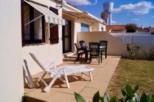 a patio with chairs and a table on the side of a house at Belle maison à 600 mètres de la grande plage de Saint-Gilles-Croix-de-Vie in Saint-Gilles-Croix-de-Vie