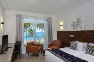 a hotel room with a bed and a view of the ocean at Serendivi Resort Villa in Tangalle