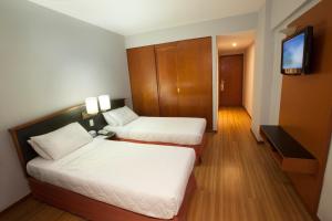 a hotel room with two beds and a television at Hotel Moncloa in Sao Paulo