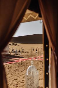 a view of a beach from a tent in the sand at Desert Luxury Camp Erg Chigaga in El Gouera