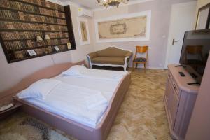 a small bedroom with a bed and a chair at Vila Sibiu in Sibiu