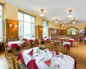 Kurhotel & Hotel Mozart في باد جاستاين: مطعم بطاولات وكراسي بمناديل حمراء