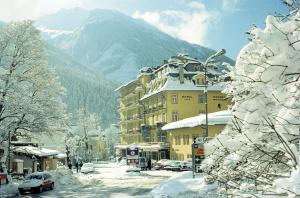 a snow covered street in a town with a building at Kurhotel & Hotel Mozart in Bad Gastein