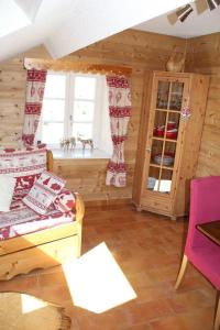 Habitación con cama y ventanas en una cabaña en Le Refuge Géromois en Gérardmer