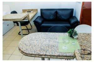 sala de estar con sofá y mesa con copas de vino en Flats Service Bueno, en Goiânia