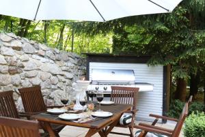 a table with wine glasses and an umbrella on a patio at Villa Rosenburg in Thale