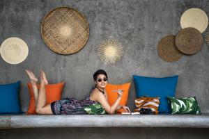 a woman is laying on a couch at Bhuvarin Resort in Ko Chang