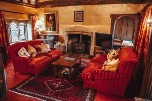 a living room with two red couches and a fireplace at Bailiffscourt Hotel & Spa in Arundel