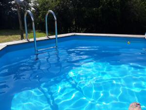 a blue swimming pool with two metal bars in it at La Vache Tennis Privé in Crux-la-Ville