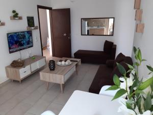 a living room with a couch and a tv at Skala Pearls A1 in Skala Kefalonias