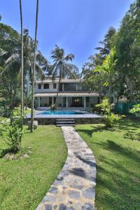 a house with a walkway leading to a swimming pool at Amara Villa in Galle