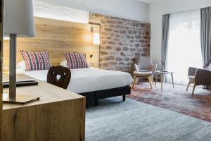 um quarto de hotel com uma cama e uma secretária em L'auberge Du Cheval Blanc et Spa em Lembach