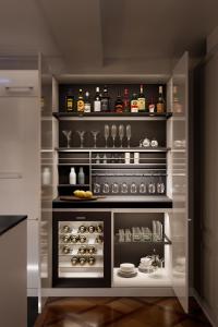 una cocina con una estantería con botellas de alcohol y platos en Le Bijou LQ82 Spectacular Limmatview Penthouse, en Zúrich