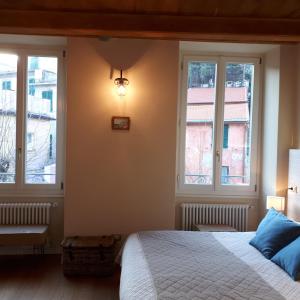 a bedroom with a bed and two windows at Bellambra in Monterosso al Mare