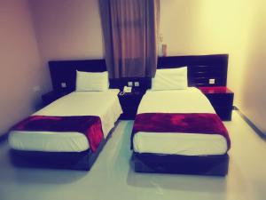 twee bedden naast elkaar in een kamer bij Sanabel Al Mish'an Furnished Units in Al Jithāmīyah