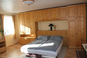 sypialnia z łóżkiem i drewnianymi szafkami w obiekcie Ferienapartment Ulrike w mieście Engelstein