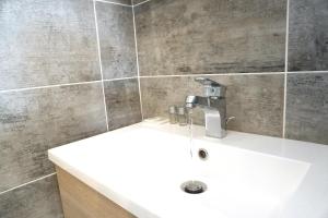 La salle de bains est pourvue d'un lavabo blanc et d'un miroir. dans l'établissement Studio terrasse Montpellier - Parking privé - Proche ligne 1, à Montpellier