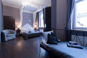 Un dormitorio con 2 camas y una silla. en Angel House Aparthotel, en Cracovia