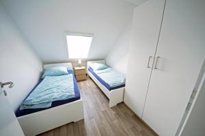 クックスハーフェンにあるFerienwohnung Am Steinkampの小さなベッドルーム(ベッド2台、ドア付)