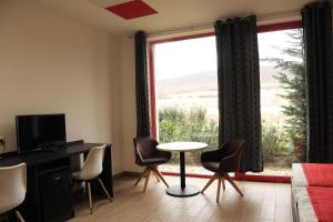 sala de estar con mesa, sillas y ventana en TOP HOTEL en Vértesszőlős