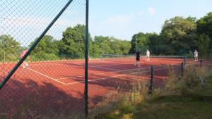 a group of people playing tennis on a tennis court at La Vache Tennis Privé in Crux-la-Ville