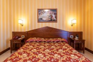 ボルセーナにあるHotel Lido - Beach and Palaceのベッドルーム1室(ベッド1台、ナイトスタンド2台、ランプ2つ付)