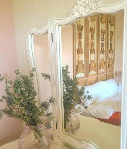 un miroir et deux vases avec des plantes sur une table dans l'établissement Live For You, à Wujie