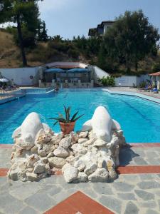 a swimming pool with rocks around a large swimming pool at Seaside View Villa in Hanioti