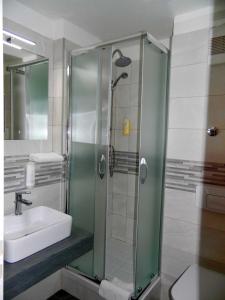 a bathroom with a glass shower with a sink at Hotel Garni Arcis in Gomaringen