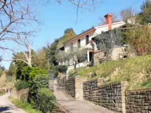 uma casa numa colina com uma parede de pedra em Tunia em Strunjan