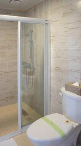 La salle de bains est pourvue d'une douche et de toilettes blanches. dans l'établissement Live For You, à Wujie