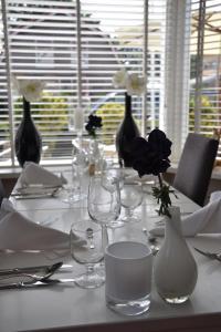 a white table with vases and glasses on a table at Fletcher Hotel Restaurant Koogerend in Den Burg
