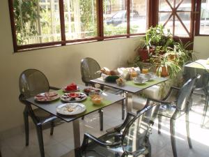 two tables with food on them in a room with windows at Nafsika Hotel in Rhodes Town