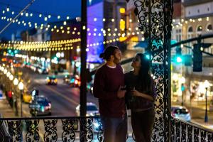a man and woman standing on a balcony at night at The Marshall House, Historic Inns of Savannah Collection in Savannah