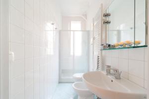 - une salle de bains blanche avec 2 toilettes et un lavabo dans l'établissement San MArtino Apartment, à Venise